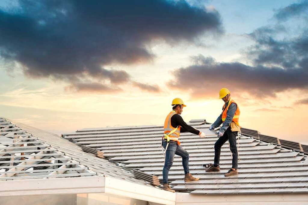 Metal roof flashing seals a chimney joint beside overlapping shingles on a residential roof.